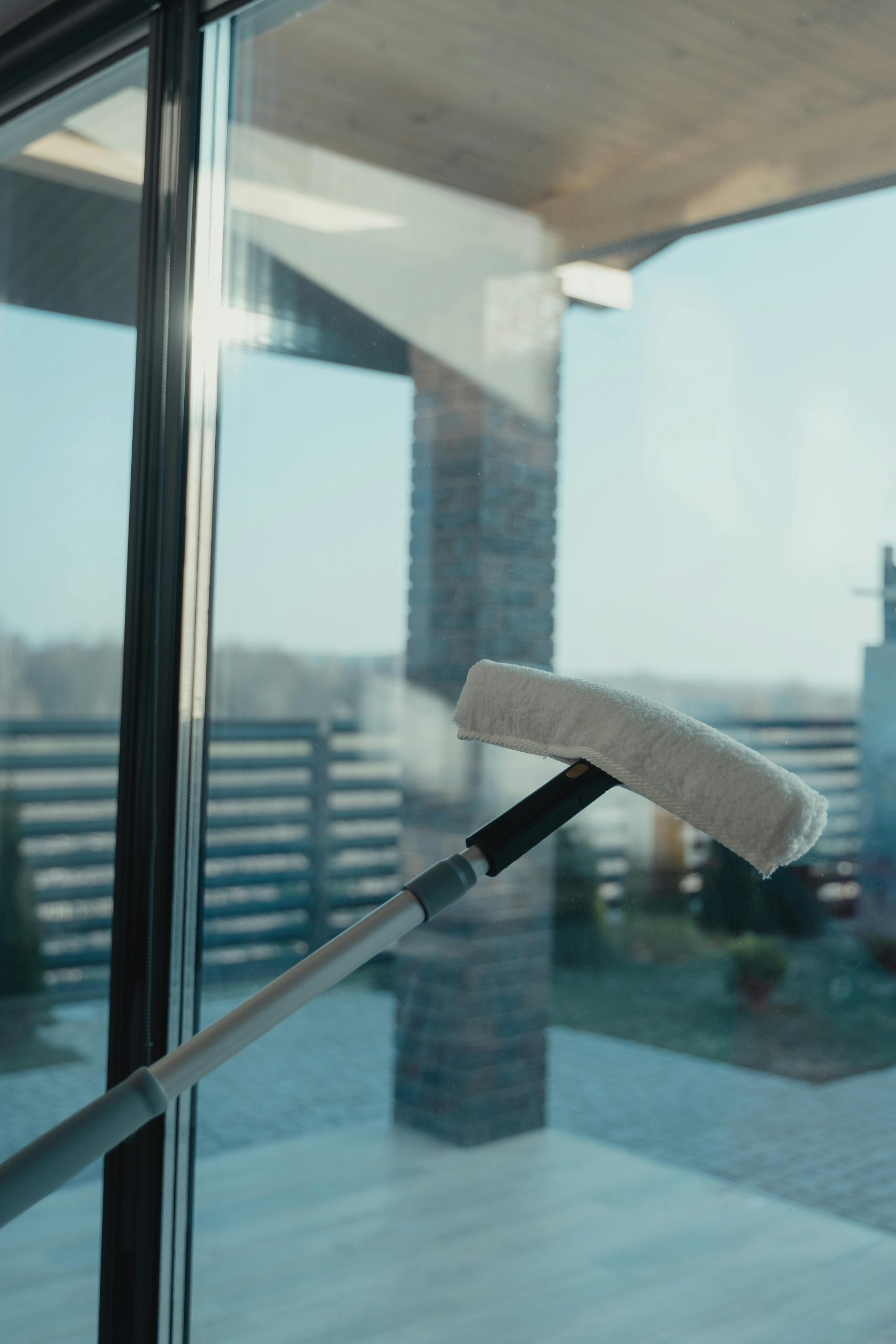 Window Cleaning A modern cleaning tool used to clean a large glass window with a clear outdoor view.